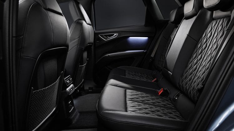 Wnętrze Audi Q4 e-tron z czarnymi skórzanymi siedzeniami.