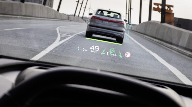 Audi Q4 e-tron jadące drogą z punktu widzenia kierowcy.