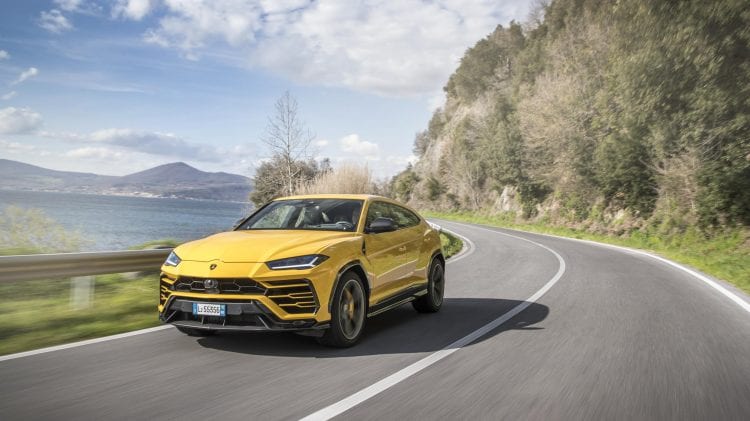 Lamborghini Urus jedzie drogą w pobliżu oceanu, prezentując rekordową sprzedaż w pierwszym kwartale.