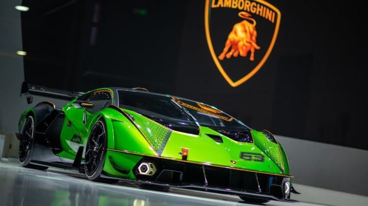 Opis: Na pokazie samochodowym prezentowany jest zielony samochód sportowy Lamborghini.