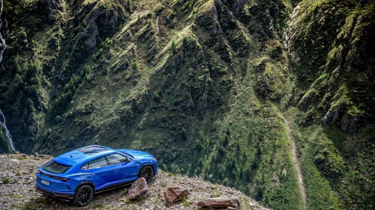 Niebieski SUV stoi zaparkowany na skalistym zboczu góry, co stanowi dowód zaangażowania firmy w zrównoważony rozwój środowiskowy.