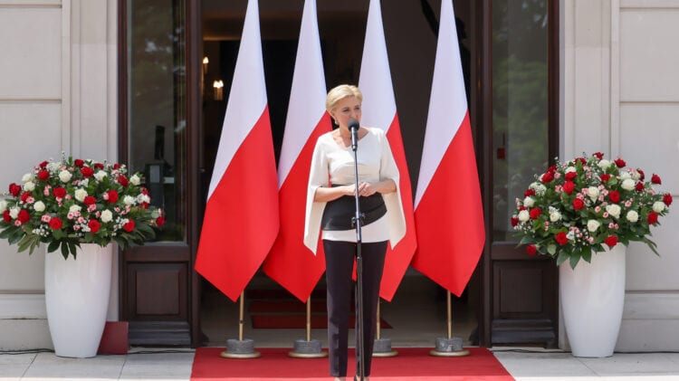 Kobieta biorąca udział w finałowej rundzie konkursu „Teraz Polska”, stojąca na podium ozdobionym flagami.