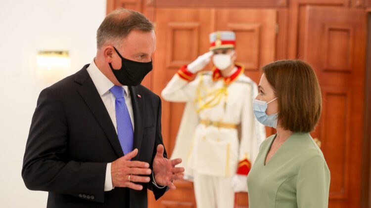 Mężczyzna w garniturze i kobieta w masce podczas wizyty w Mołdawii przez Prezydenta RP