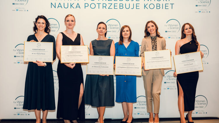 Pięć kobiet ze świadectwami przed ścianą, pokazujących poprawę sytuacji kobiet w środowisku akademickim.