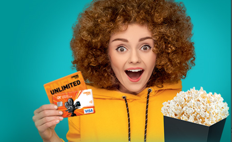 Kobieta z kręconymi włosami trzymająca pudełko popcornu i kartę filmową.