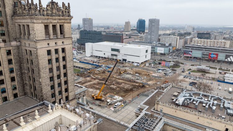 Widok z lotu ptaka na plac budowy miejskiego z dźwigiem wśród budynków miejskich.