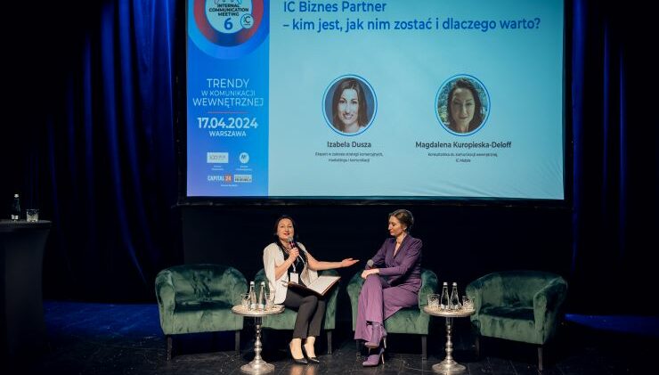 Dwie kobiety dyskutują na scenie konferencji biznesowej, a w tle ekran prezentacyjny wyświetla ich nazwiska i tematy.