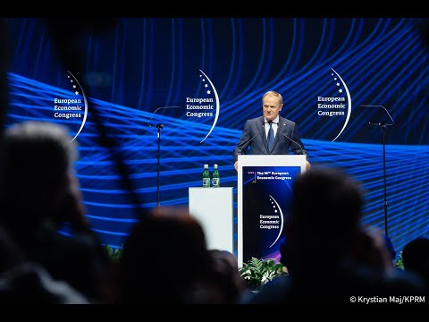 Mężczyzna przemawia na podium, w tle transparenty „Europejskiego Kongresu Gospodarczego”; publiczność na pierwszym planie.